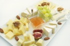 Сырная тарелка из нескольких видов сыров: мягкие сыры и твёрдые Сыры подаются с мёдом, виноградом и орехами.